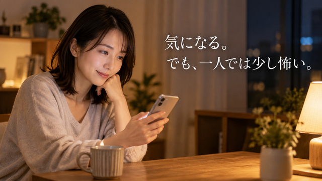 夜の自宅でスマートフォンを見ながら静かにほほ笑む女性