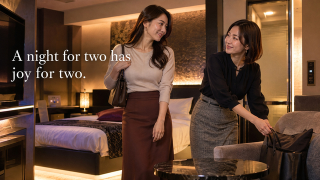 Two fully clothed women smiling at each other in a hotel room