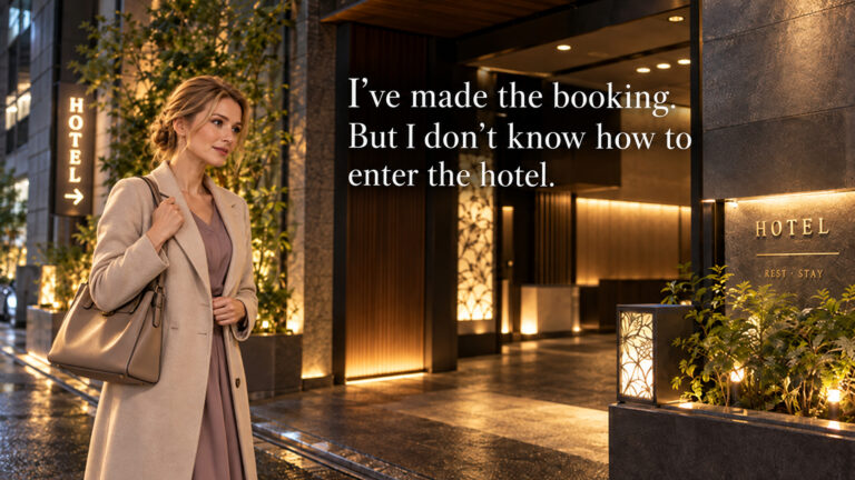 A woman holding her phone pauses outside an illuminated hotel entrance at night